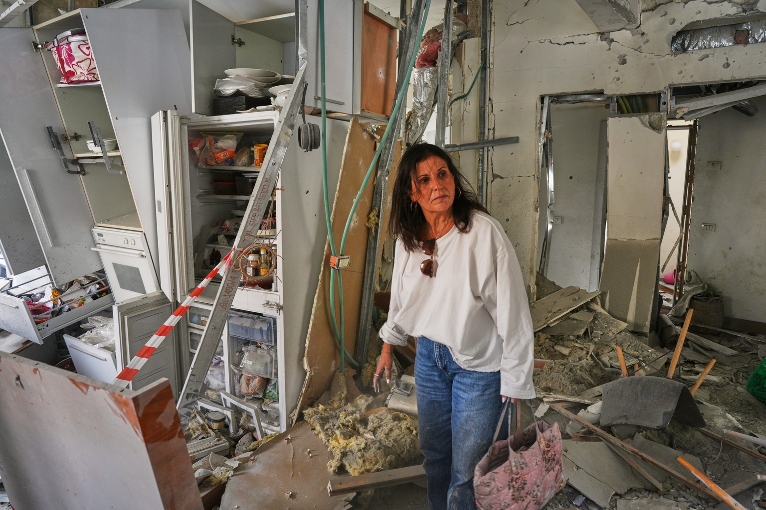 A woman inspects a house damaged by an Iranian cluster bomb in Ramat Gan, Israel, Friday, April 3, 2026. (AP Photo/Maya Levin)
Israel Iran War