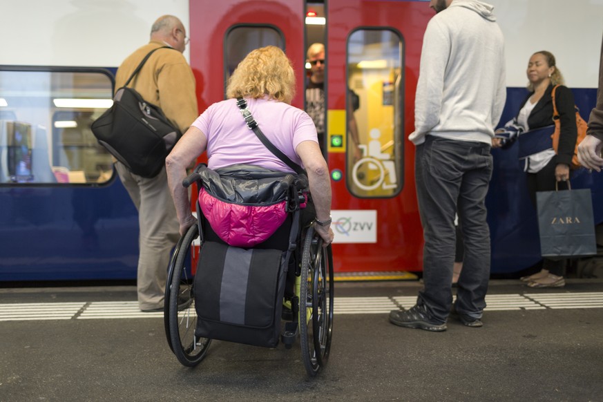 ZUM THEMA MENSCHEN MIT BEHINDERUNG IM OEFFENTLICHEN VERKEHR STELLEN WIR IHNEN HEUTE DIESES NEUE BILDMATERIAL ZUR VERFUEGUNG --- The wheelchair user Ms. Koerner gets on a line 12 commuter train in Wint ...