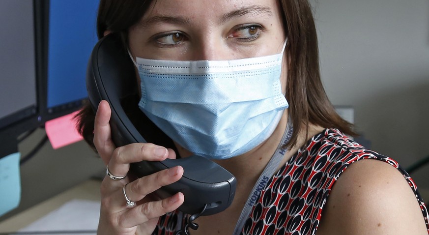 In this Tuesday, May 19, 2020, photo, health investigator Mackenzie Bray sits in her office at the Salt Lake County Health Department in Salt Lake City. Bray normally works to track contacts for peopl ...