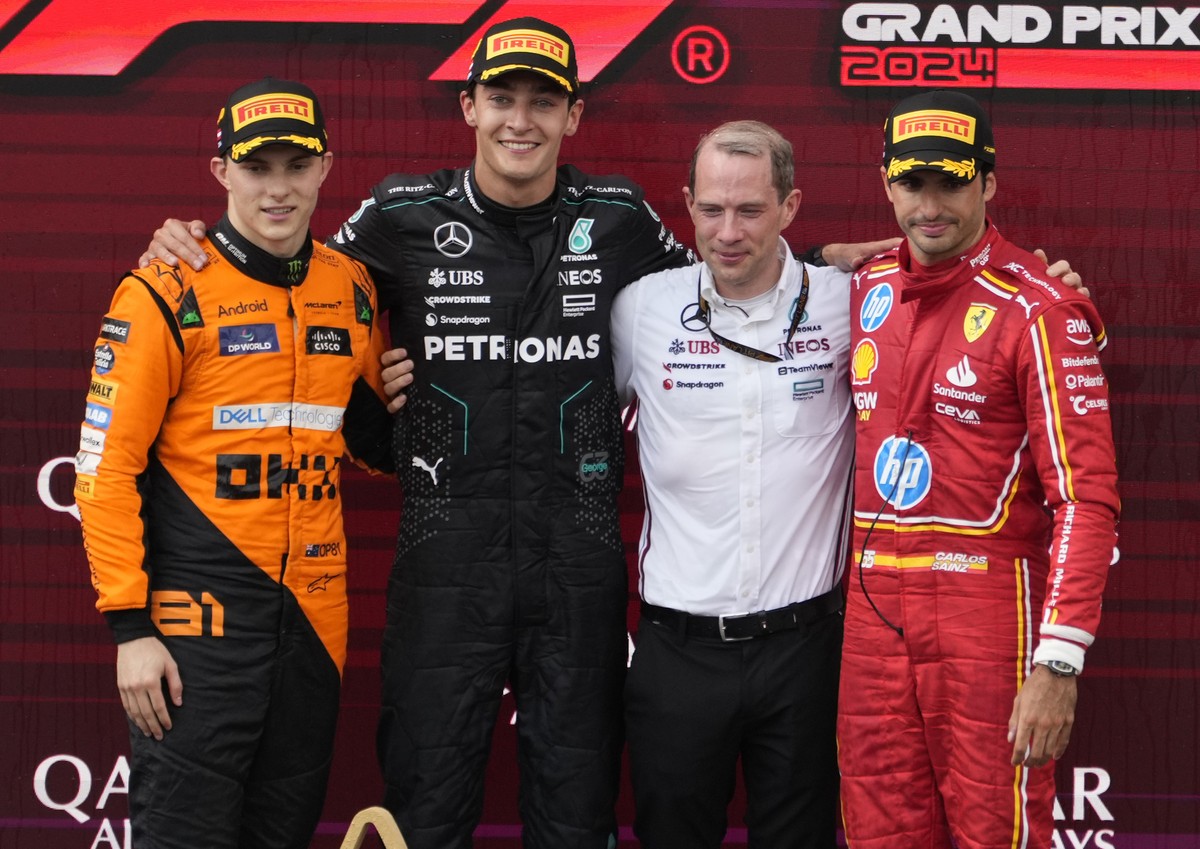 Mercedes driver George Russell of Britain, second left, poses with McLaren driver Oscar Piastri of Australia, left, who finished second, and Ferrari driver Carlos Sainz of Spain, right, who finished t ...