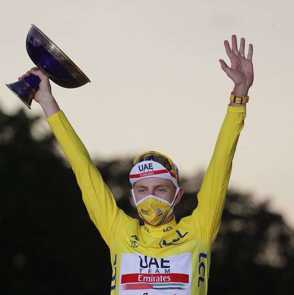 Tour de France winner Tadej Pogacar, wearing the overall leader&#039;s yellow jersey, second placed Primoz Roglic of Slovenia, left, and third placed Richie Porte of Australia, celebrate on the podium ...