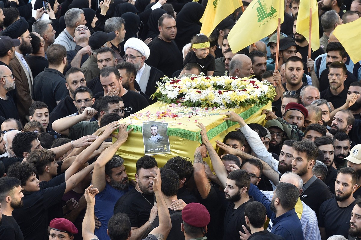 epaselect epa11612073 Mourners carry the coffin of one of the people who died a day earlier in pagers blasts, during the funeral procession in the southern suburb of Beirut, Lebanon, 18 September 2024 ...