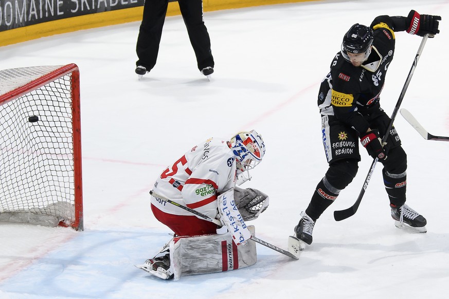 Gotterons Julien Sprunger, rechts, schiesst ein Tor (3-2) gegen SC Rapperswil-Jona Lakers Torhueter Noel Bader, links, beim Eishockey Meisterschaftsspiel der National League A zwischen den HC Fribourg ...