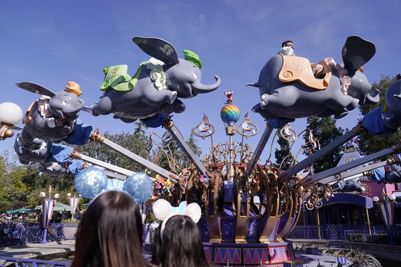 Guests ride the Dumbo ride at Disneyland in Anaheim, Calif., Friday, April 30, 2021. The iconic theme park in Southern California that was closed under the state&#039;s strict virus rules swung open i ...