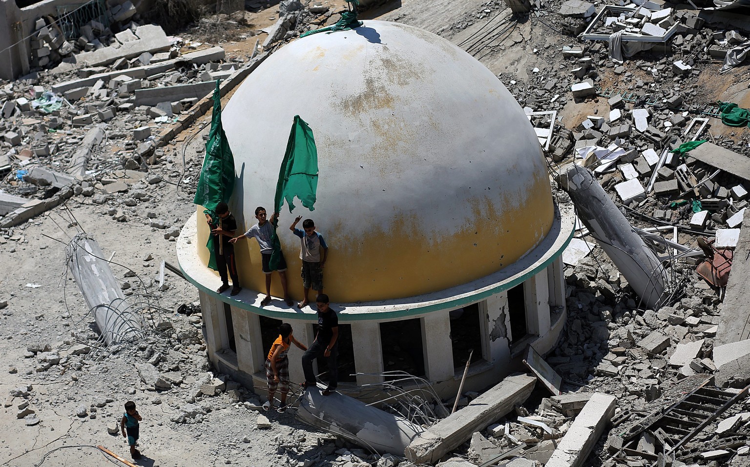 Palästinensische Jungen schwenken die Flagge der Hamas. Nach&nbsp;1,900 Toten, darunter 449 Kinder, 243 Frauen und 87 ältere Männer schweigen die Waffen in Gaza.&nbsp;