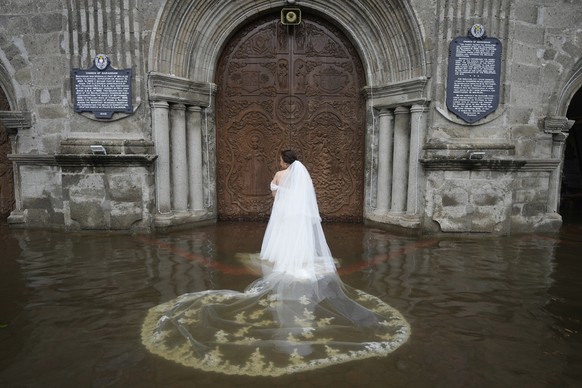 Bride Jamaica Agular prepares to enter the flooded Barasoain church for her wedding in Malolos, Bulacan province, Philippines on Tuesday, July 22, 2025. (AP Photo/Aaron Favila)
Philippines Flooded Wed ...