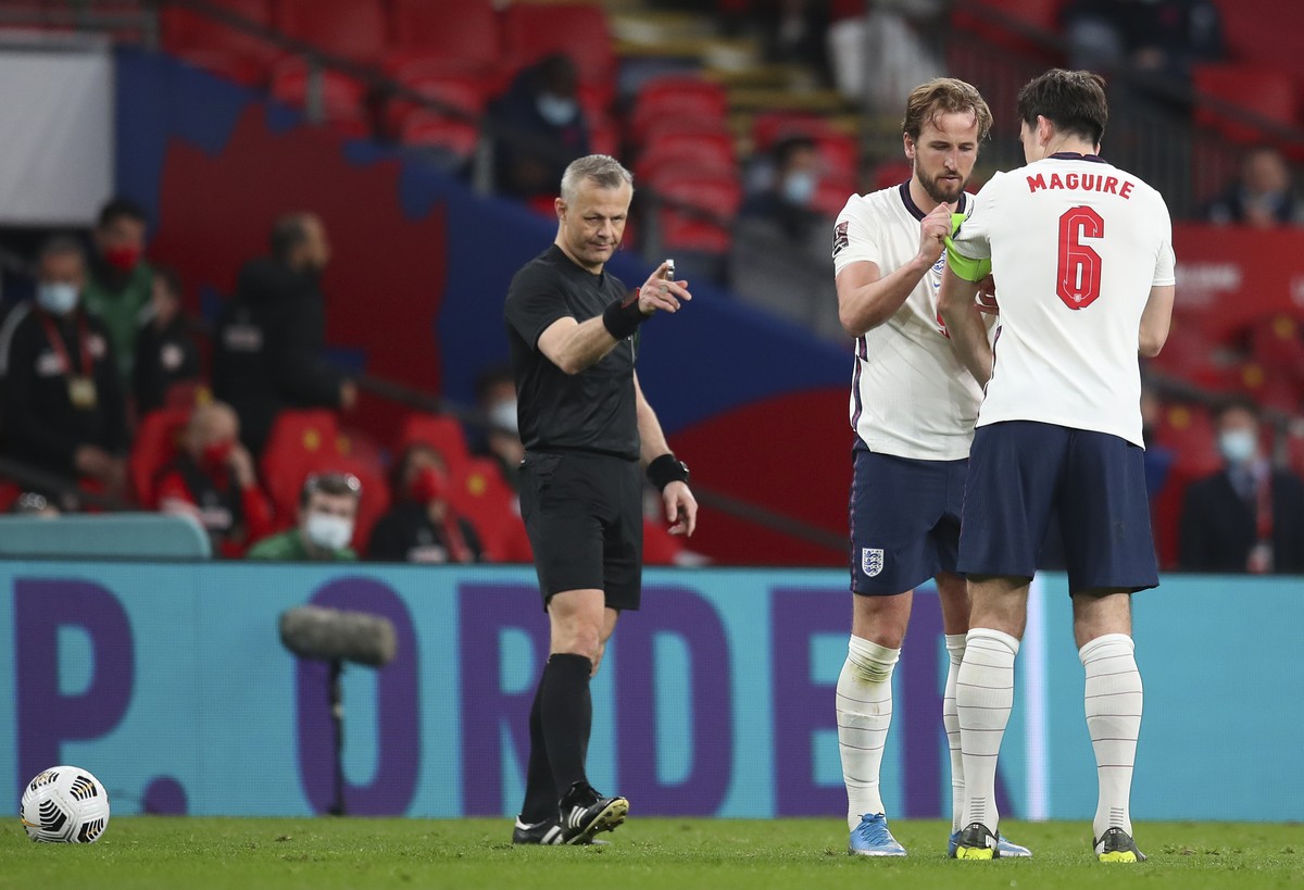 England's Harry Kane gives the captain's armband to Harry Maguire during the World Cup 2022 group I qualifying soccer match between England and Poland at Wembley stadium in London, England,  ...