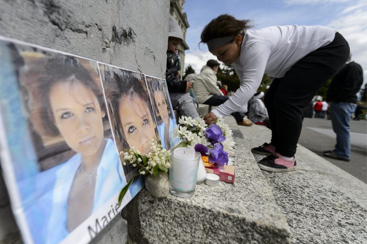 Fall Marie Une jeune fille depose des fleurs proche d'un portrait de Marie devant le Tribunal cantonal de Montbenon lors d'une marche blanche organisee en souvenir de Marie, entre le Tribuna ...
