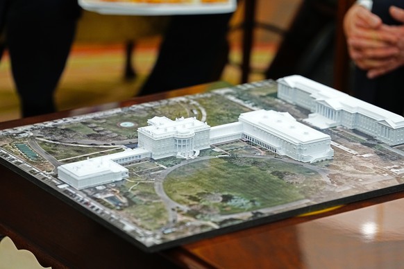 epa12474300 A model of the White House with the new ballroom is seen on the table as United States President Donald J. Trump meets with NATO Secretary General Mark Rutte in the Oval Office of the Whit ...