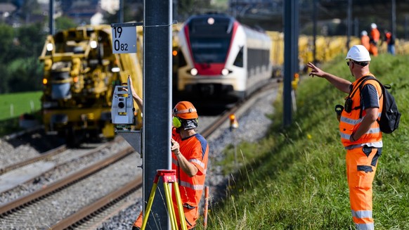 Des ouvriers travaillent a cote de la machine &quot;Puscal&quot; de l&#039;entreprise Scheuchzer lors d&#039;une visite de presse sur le chantier d&#039;entretien des voies CFF de 7km de long entre Pu ...