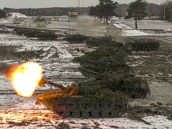 FILE - In this photo taken from video and released by the Russian Defense Ministry Press Service on Friday, Feb. 4, 2022, armored vehicles fire during the Belarusian and Russian joint military drills  ...