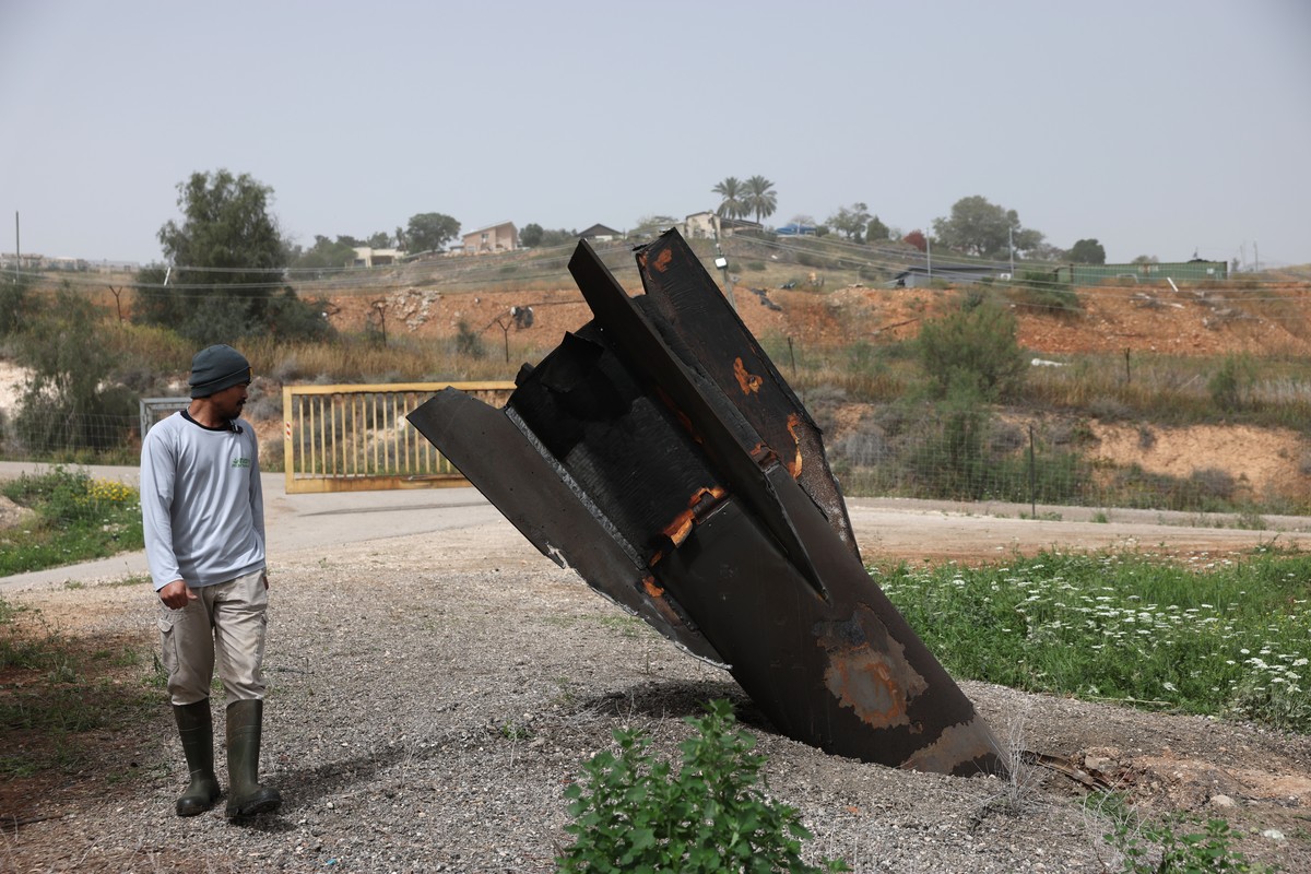epa12868587 A Thai agricultural worker examines the tail of an Iranian ballistic missile that hit near a cow barn in the Israeli settlement of Shadmot Mehola, in West Bank, 04 April 2026. Iran launche ...