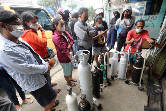 epa09312568 Indonesians queue at an oxygen refill shop amid the rising number of COVID-19 cases, in Jakarta, Indonesia, 30 June 2021. Indonesia has recorded over two million COVID-19 cases since the b ...