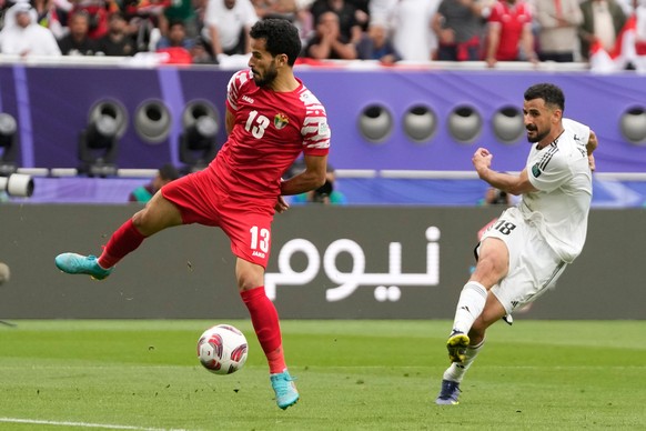 FILE - Iraq's Aymen Hussein, right, scores his side's second goal during the Asian Cup Round of 16 soccer match between Iraq and Jordan, at Khalifa International Stadium in Doha, Qatar, Mond ...