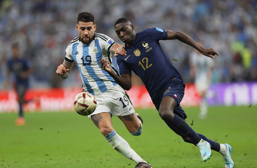 epa10372536 Nicolas Otamendi (L) of Argentina fouls Randal Kolo Muani (R) of France in the penalty box during the FIFA World Cup 2022 Final between Argentina and France at Lusail stadium, Lusail, Qata ...