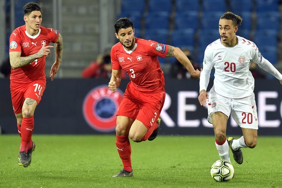 Switzerland&#039;s Steven Zuber, left, and Switzerland&#039;s Loris Benito, Center, fights for the ball with Denmark&#039;s Yussuf Poulsen, right, during the UEFA Euro 2020 qualifying Group D soccer m ...