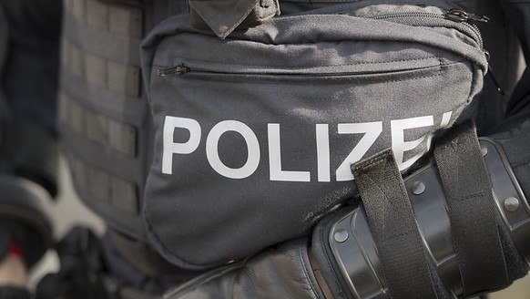 Ein Polizist in Vollmontur: Ein Mann hat sich in Frauenfeld auf dem Dach einer Liegenschaft verschanzt. Zuvor hatte er einen anderen Mann mit einer Stichwaffe mittelschwer verletzt. Die Polizeiaktion  ...