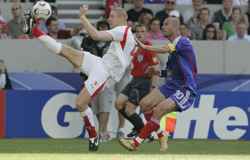 Switzerland's Philippe Senderos, left, gets the ball ahead of France's Zinedine Zidane, right, during the France v Switzerland Group G soccer match at the World Cup Gottlieb-Daimler stadium ...