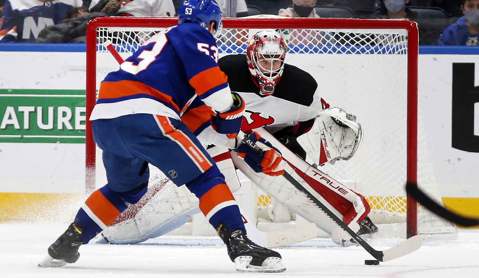 New Jersey Devils goaltender Akira Schmid (40) defends the net during the first period of an NHL hockey game against New York Islanders center Casey Cizikas (53) on Saturday, Dec. 11, 2021, in Elmont, ...