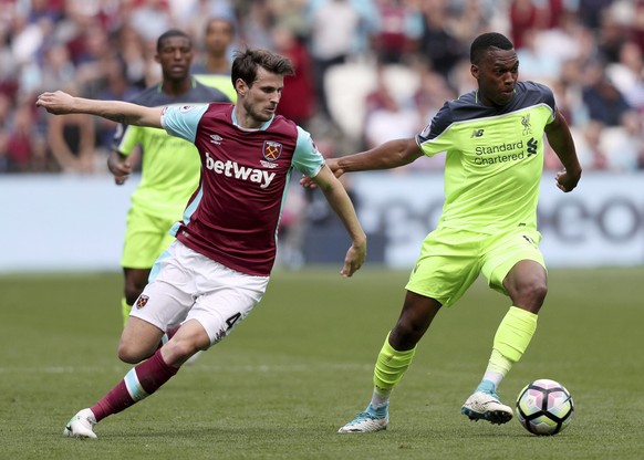 West Ham United&#039;s Havard Nordtveit, left, and Liverpool&#039;s Daniel Sturridge battle for the ball during the English Premier League soccer match at London Stadium, Sunday May 14, 2017. (Adam Da ...