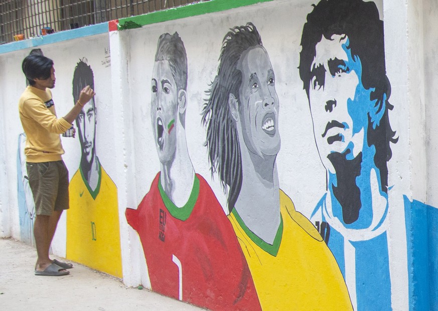 epa10308171 Bangladeshi artists working on a mural in a street in Dhaka, Bangladesh, 16 November 2022, showing famous soccer players as Mohamed Salah, Pele, Diego Armando Maradona, Ronaldinho, Cristia ...