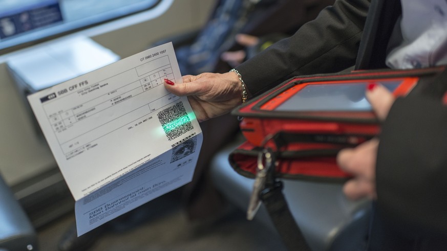 ARCHIV - Train attendant Priska Protmann of Swiss Federal Railways SBB scans a passenger&#039;s electronic ticket in the InterCity train from Zurich to Geneva, Switzerland, on May 29, 2013. --- Preisu ...