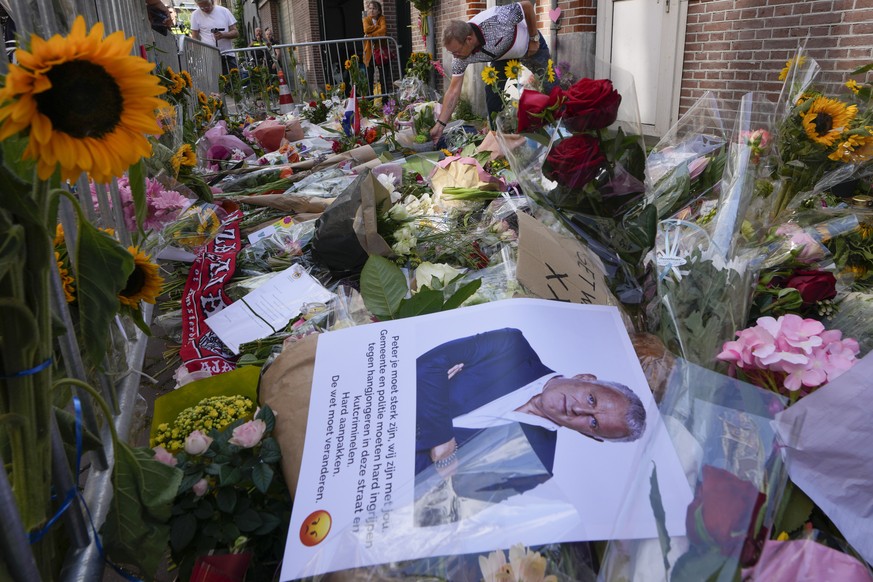 FILE - A photo and floral tributes mark the spot where journalist Peter R. de Vries was shot in Amsterdam, Netherlands, Thursday, July 8, 2021. The trial with the suspects accused of killing Dutch inv ...