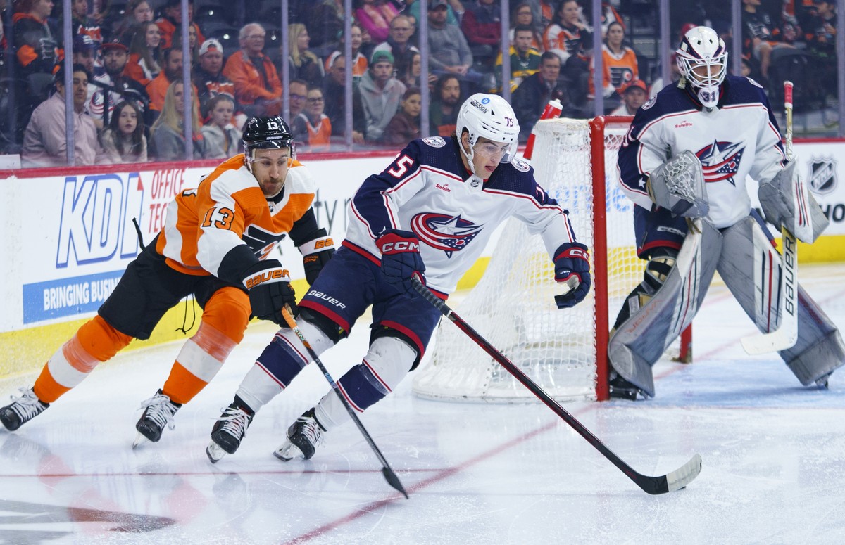 Columbus Blue Jackets' Tim Berni, center, skates the puck away with Philadelphia Flyers' Kevin Hayes, left, giving chase during the second period an NHL hockey game Tuesday, April 11, 2023,  ...