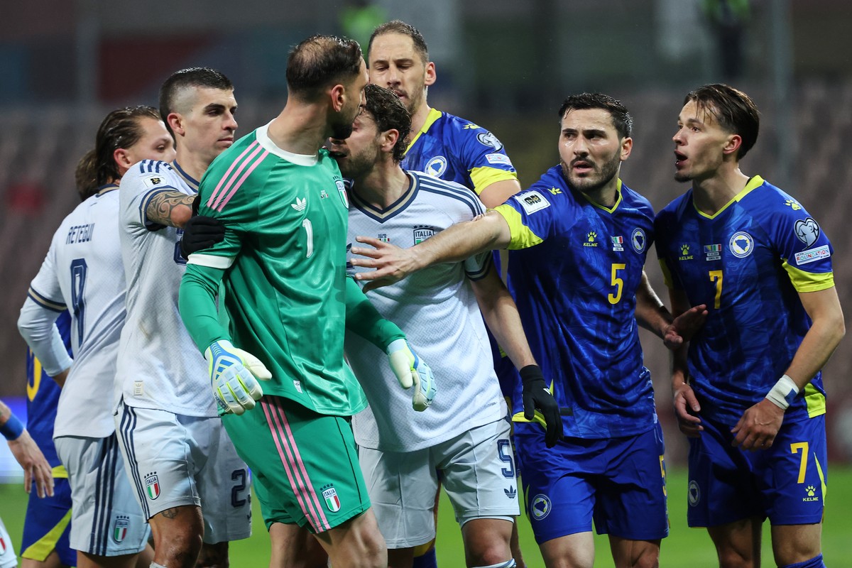 Teammates separate Italy goalkeeper Gianluigi Donnarumma and Bosnia's Amar Dedic, right, during the World Cup qualifying playoff final soccer match between Bosnia and Italy in Zenica, Bosnia, Tue ...