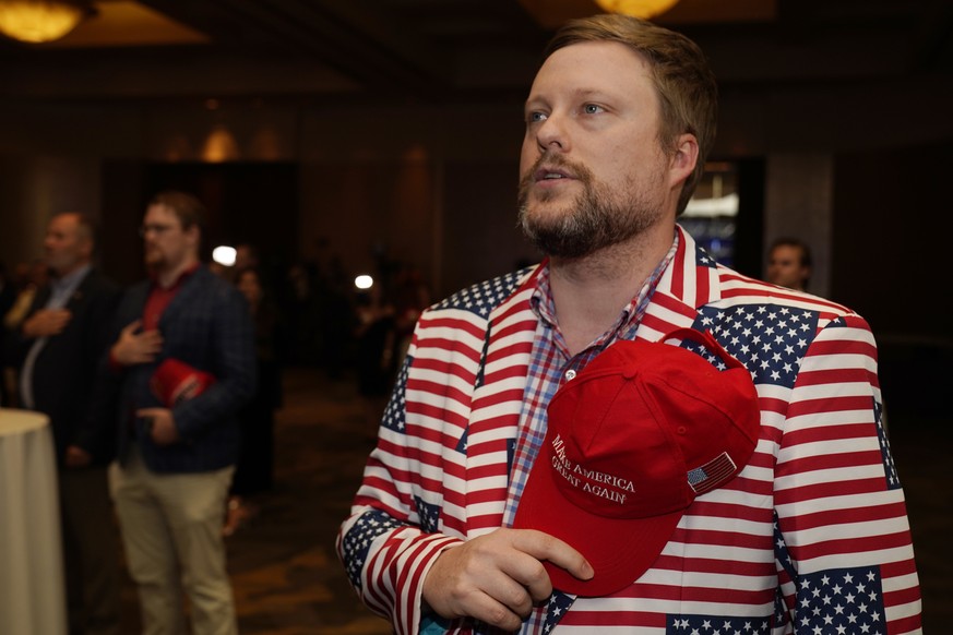 James Dutton, of Griffin Ga., a supporter of Republican candidate for Senate U.S. Sen. David Perdue recites the Pledge of Allegiance as he attends an election-night watch party Tuesday Nov. 3, 2020 in ...