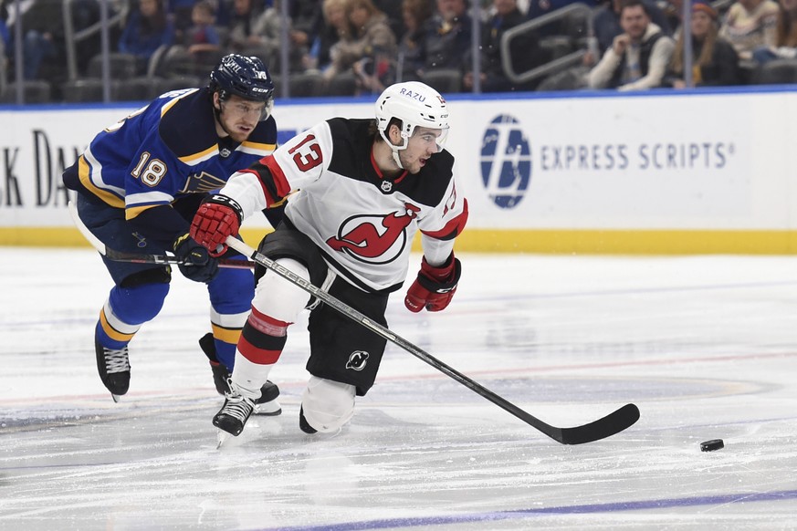 St. Louis Blues center Robert Thomas (18) pressures New Jersey Devils center Nico Hischier (13) during the third period of an NHL hockey game Thursday, Feb. 10, 2022, in St. Louis. (AP Photo/Joe Puetz ...