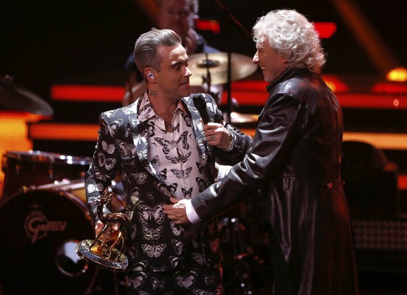 Singer Robbie Williams receives the Music International award from German entertainer Thomas Gottschalk during the Bambi 2016 media awards ceremony in Berlin, Germany, November 17, 2016 REUTERS/Hannib ...