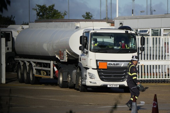 A workers waves at colleagues in a fuel tanker at Buncefield Oil Depot near Hemel Hempstead, England, Tuesday, Oct. 5, 2021. British military personnel have begun delivering fuel to gas stations after ...