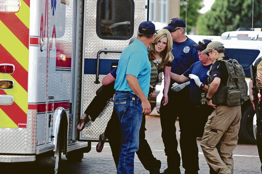 An injured woman is carried to an ambulance in Clovis, N.M., Monday, Aug. 28, 2017, as authorities respond to reports of a shooting inside a public library. A city official says police have taken a pe ...