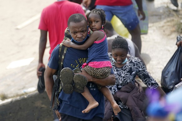 Haitian migrants use a dam to cross into and from the United States from Mexico, Saturday, Sept. 18, 2021, in Del Rio, Texas. The U.S. plans to speed up its efforts to expel Haitian migrants on flight ...