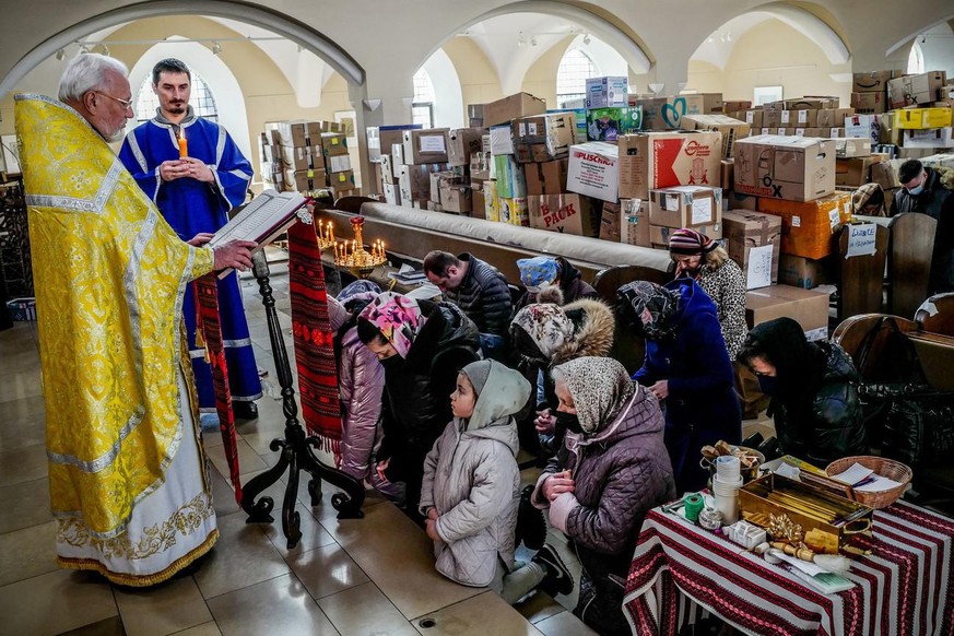 Members of the Ukrainian community during a service for peace in Ukraine and war victims in a Ukrainian Catholic Church filled with boxes of humanitarian aid in Berlin, Germany, 13 March 2022. Russian ...