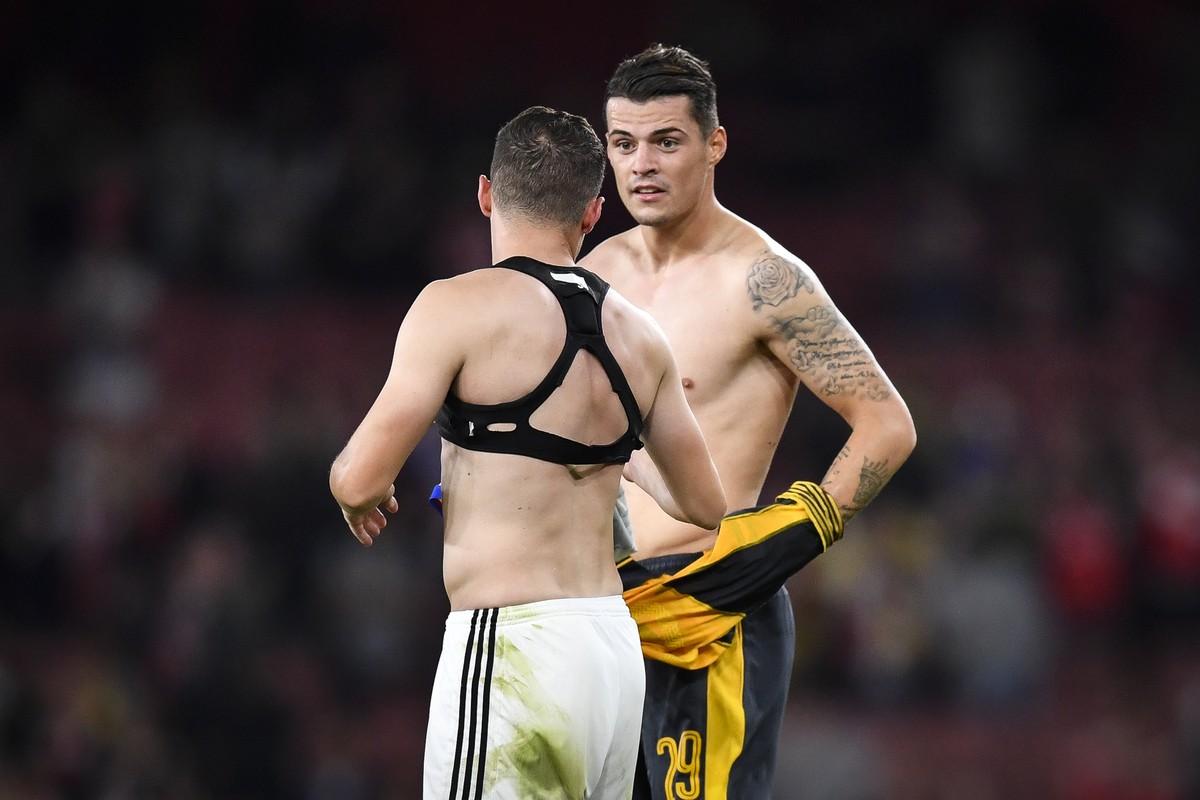 Arsenals Granit Xhaka, right, and brother Taulant Xhaka of Basel switch shirts, after an UEFA Champions League Group stage Group A matchday 2 soccer match between England's Arsenal FC and Switzer ...