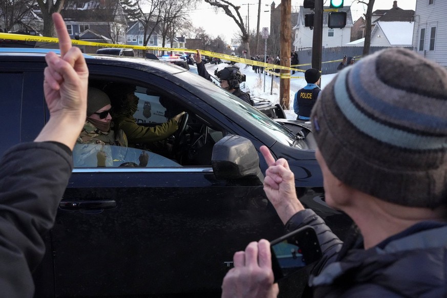 SENSITIVE MATERIAL. THIS IMAGE MAY OFFEND OR DISTURB People gesture as they confront members of law enforcement leaving the scene where a driver was shot by a U.S. immigration agent, according to loca ...