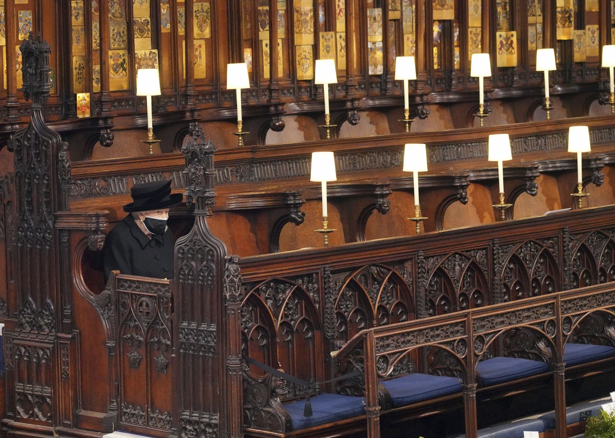 Britain's Queen Elizabeth II sits alone in St. George's Chapel during the funeral of Prince Philip, the man who had been by her side for 73 years, at Windsor Castle, Windsor, England, Saturd ...