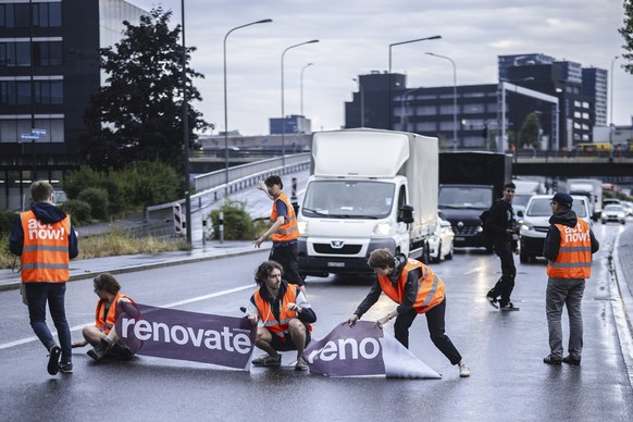 epa10699500 Environmental activists of &#039;Renovate Switzerland&#039; civil resistance campaign stop vehicles as they sit down on the road during a roadblock action on the motorway A1 exit in Zueric ...