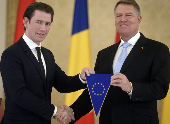 FILE - In this file photo dated Friday, Dec. 21, 2018, Austrian Chancellor Sebastian Kurz, left, shakes hands while holding a EU flag with Romanian President Klaus Iohannis at the Cotroceni presidenti ...