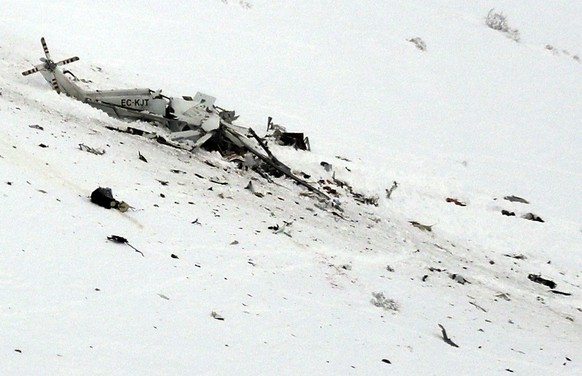 The wreckage of an helicopter lies in the snow after crashing in the Campo Felice ski area, central Italy, Tuesday, Jan. 24, 2017. A helicopter ferrying an injured skier off the slopes crashed Tuesday ...