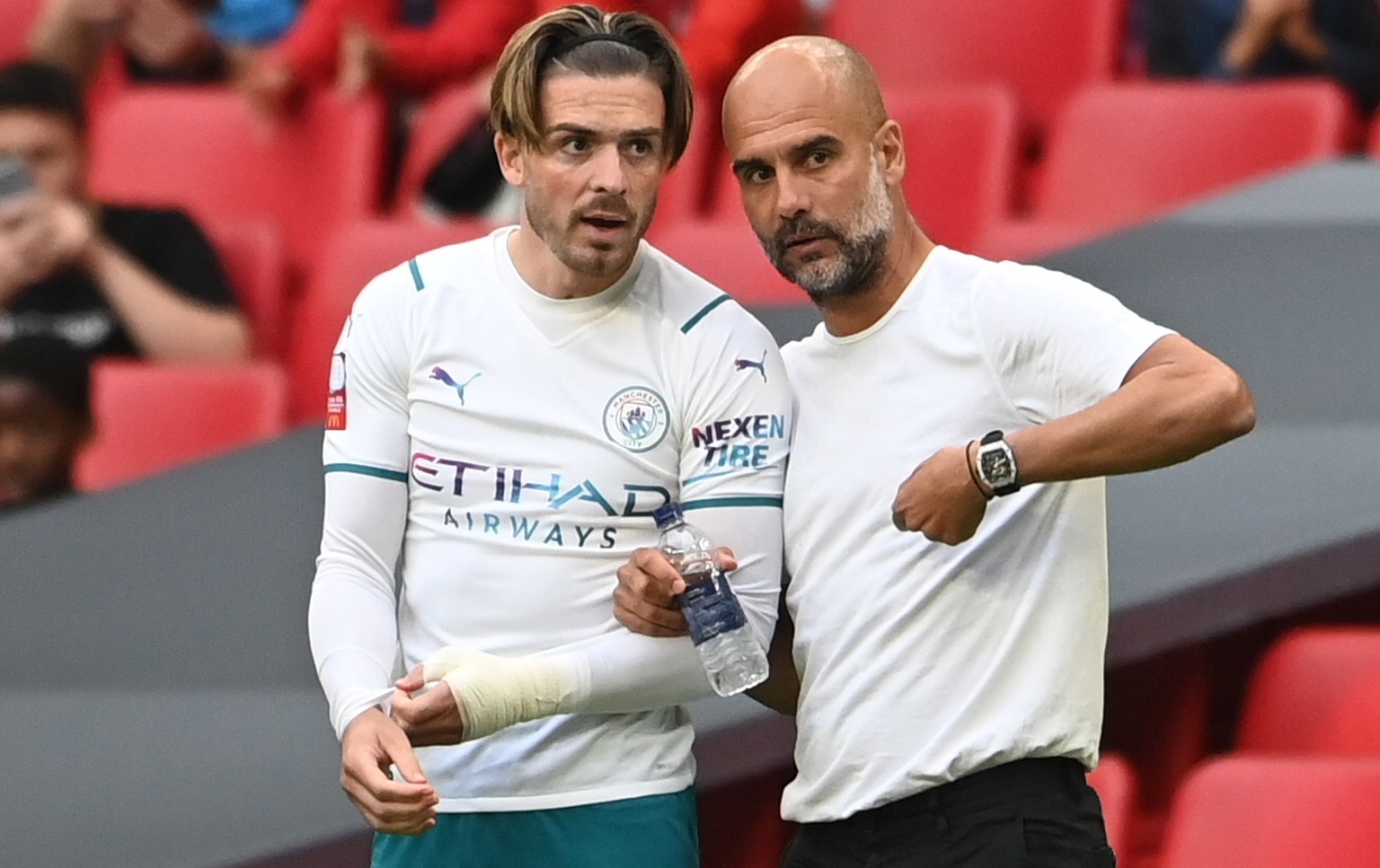 epa09404450 Jack Grealish (L), and manager Pep Guardiola (R) talk during the FA Community Shield soccer match between Leicester City and Manchester City at the Wembley stadium in London, Britain, 07 A ...