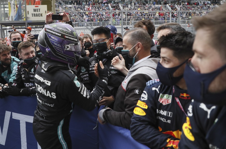 epa09489717 British Formula One driver Lewis Hamilton of Mercedes-AMG Petronas celebrates with team members after winning the 2021 Formula One Grand Prix of Russia at the Sochi Autodrom race track in  ...