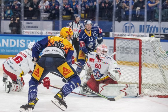 Dario Simion, links, von Zug schiesst das Tor zum 2:1 gegen Melvin Nyffeler, rechts, von Rapperswil beim Playoff Viertelfinal Spiel 6 beim Eishockey Meisterschaftsspiel der National League zwischen de ...