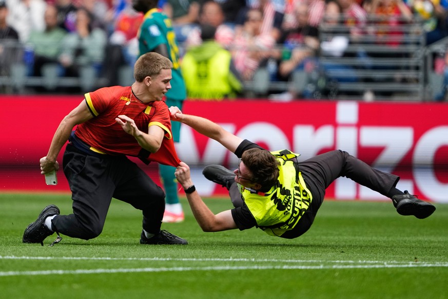 A pitch invader is held by security during the World Cup round of 32 soccer match between Belgium and Senegal in Seattle, Wednesday, July 1, 2026. (AP Photo/Lindsey Wasson)
APTOPIX Senegal Belgium WCu ...