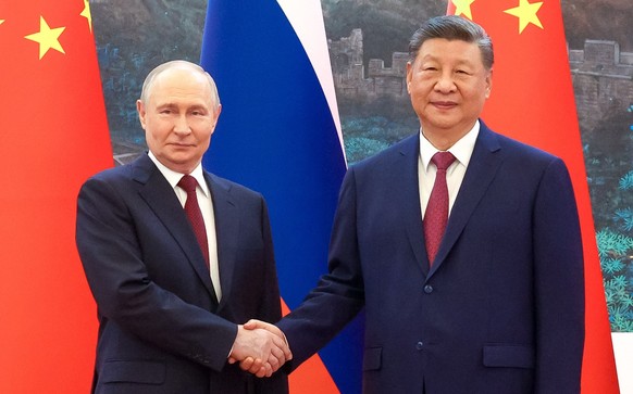 epa12976200 Russian President Vladimir Putin (L) and Chinese President Xi Jinping (R) shake hands and pose for a photo during their meeting in Beijing, China, 20 May 2026. EPA/MAXIM STULOV / SPUTNIK / ...