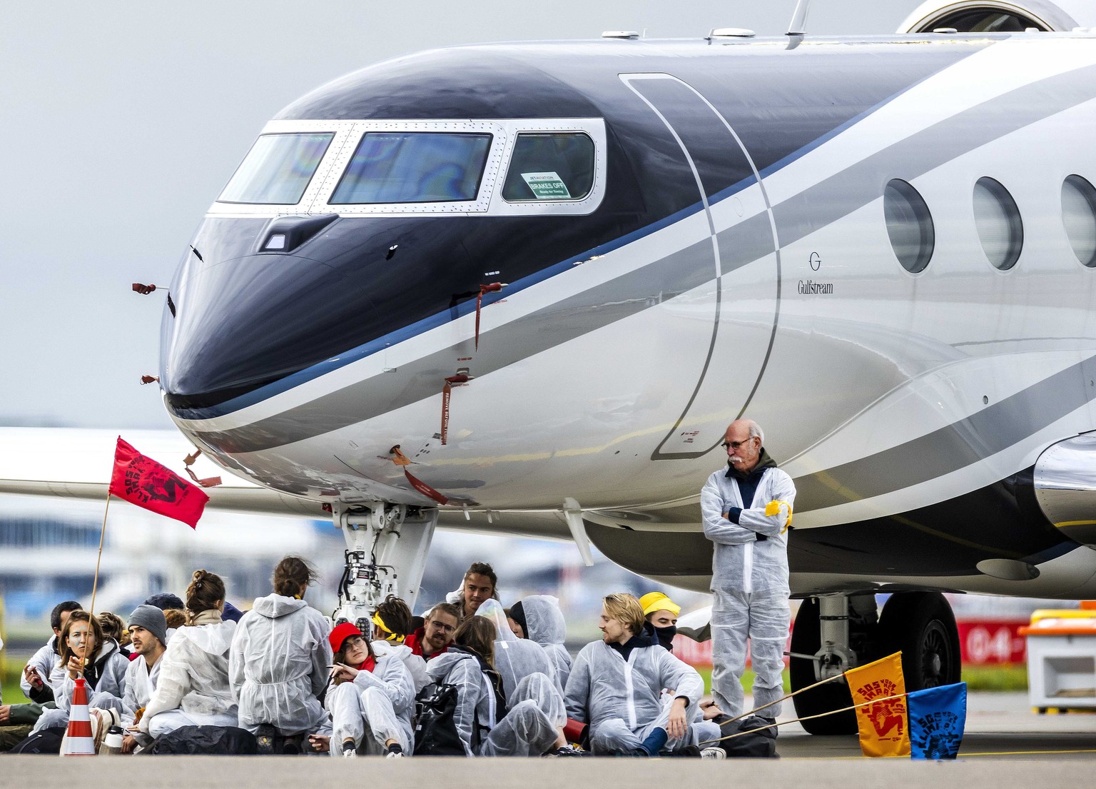 epa10288102 Some of the climate activists gather at the airport of Schiphol where private planes are parked, at Schiphol Airport, the Netherlands, 05 November 2022. The activists have taken place unde ...