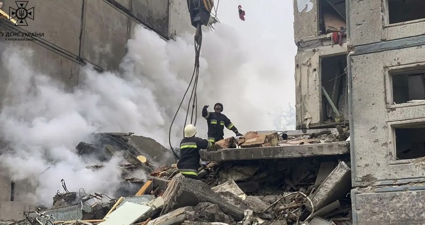 Das von Rettungsbehörden in der Ukraine veröffentlichte Bild soll Feuerwehrleute inmitten der Schäden zeigen, die der russische Raketenangriff in Saporischschja angerichtet hat.