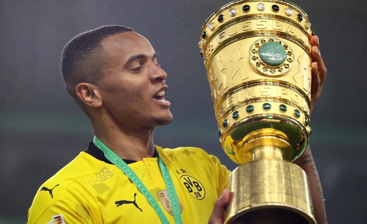 epa09198330 Dortmund's Manuel Akanji celebrates with the trophy after winning the German DFB Cup final soccer match between RB Leipzig and Borussia Dortmund in Berlin, Germany, 13 May 2021. EPA/M ...